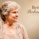 Bettye Bohannon in an elegant lace outfit against a warm background